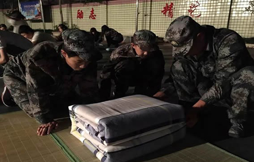 重慶三峽職業(yè)技工學校學生認真地觀察教官疊軍被